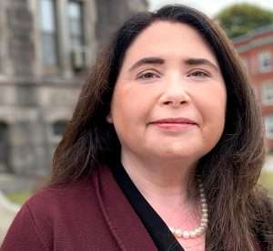 An image of Christine M. Tree, Esq., looking into a camera, from a head shot from the Hera Law Group's website.