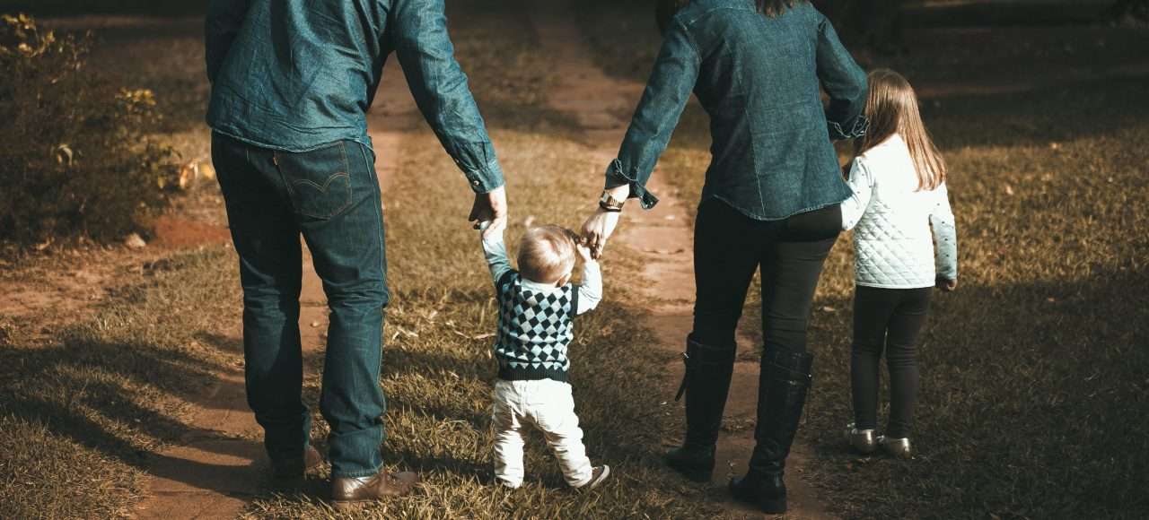 An image of two parents holding hands with their kids, for a blog on court mandated co-parenting course.